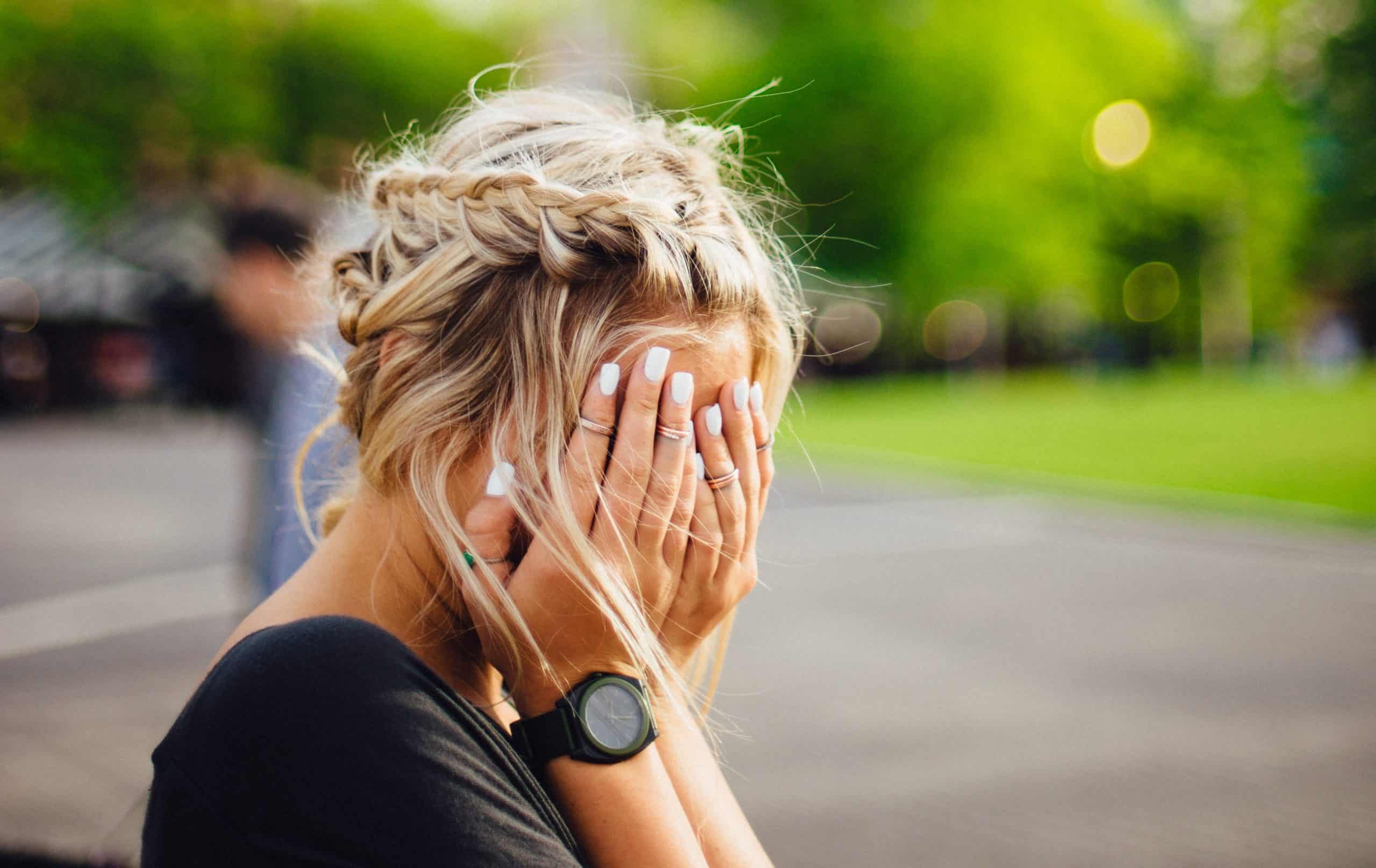 woman putting face in hands draining job introvert