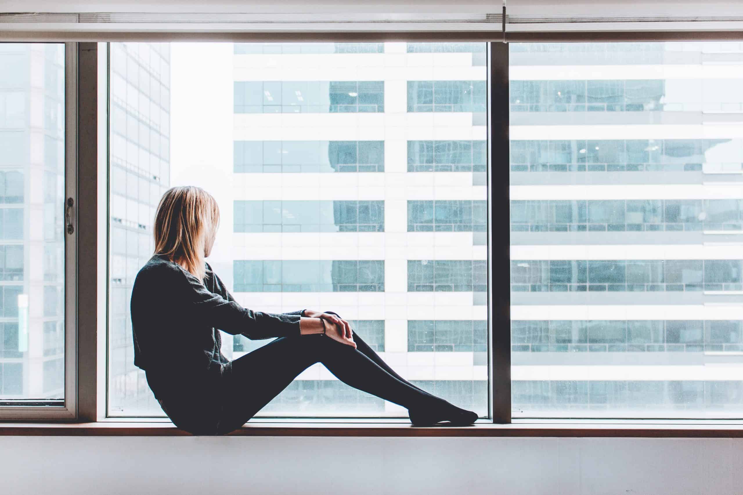 woman staring out a window in lockdown