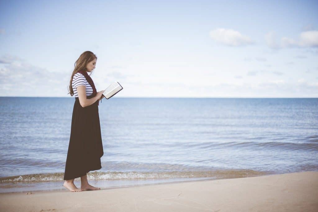 woman making money reading books on beach