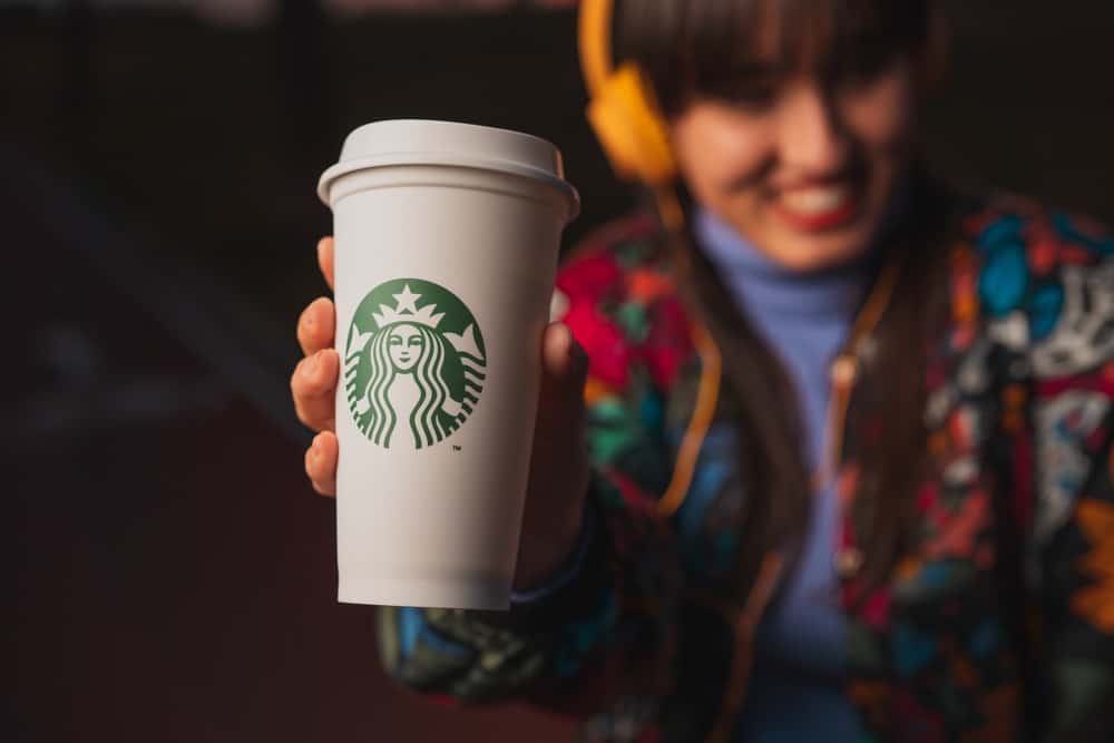 woman holding free Starbucks drink