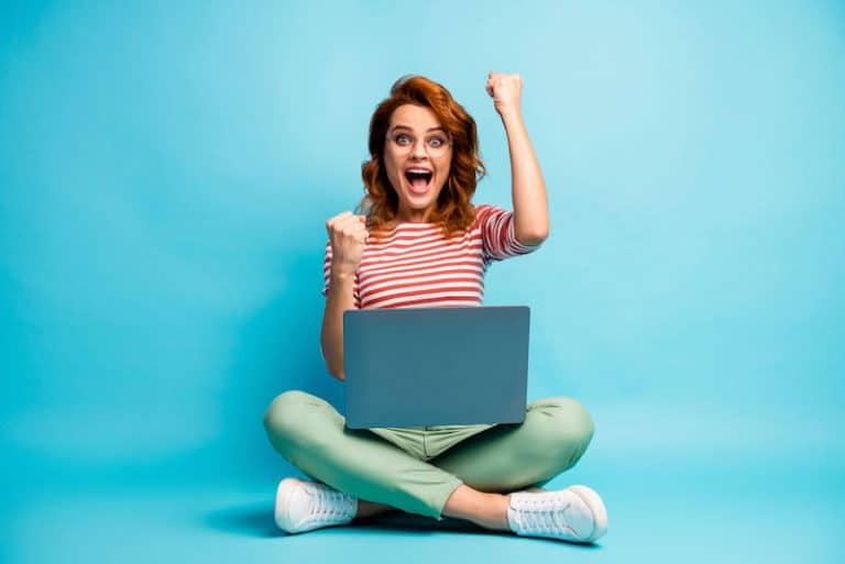 woman with laptop excited to make money online